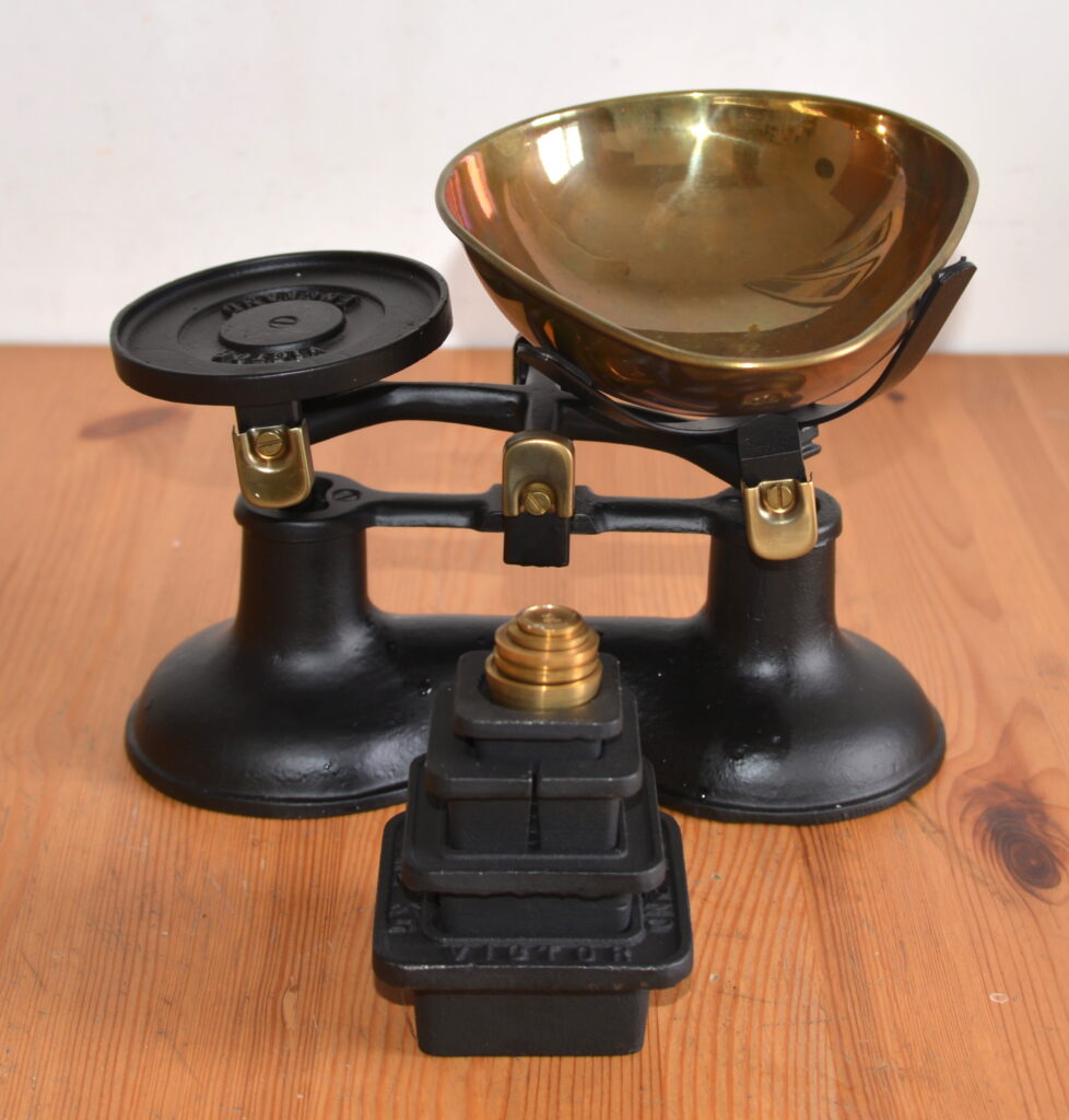 Bilancia vintage Victor in ghisa nera e ottone, completa di pesi graduati. Un originale oggetto da collezione per arredamento vintage e industriale.