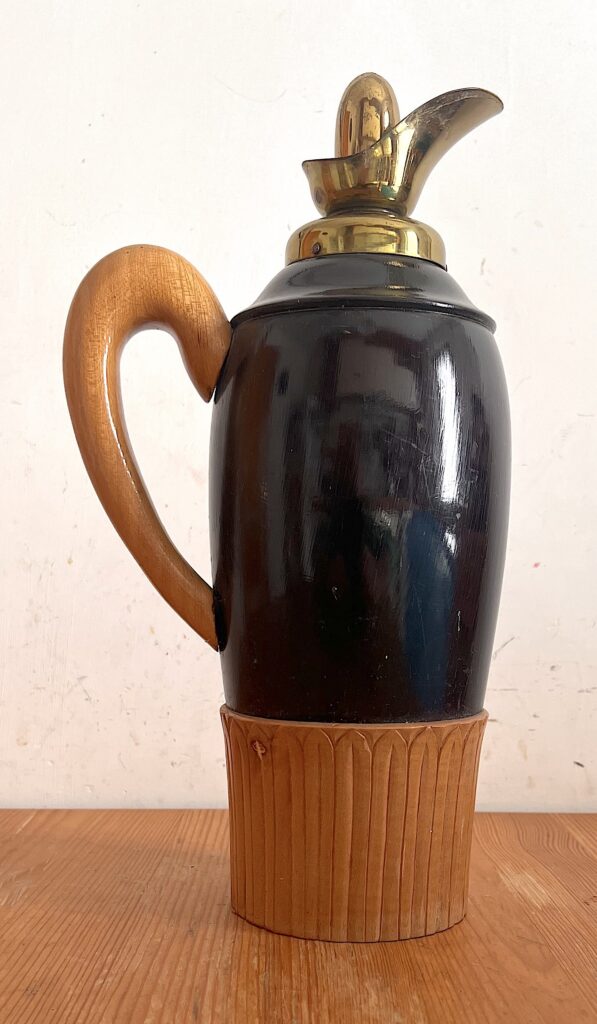 Thermos vintage Macabo con corpo nero lucido, manico in legno curvo, base scanalata e beccuccio dorato.