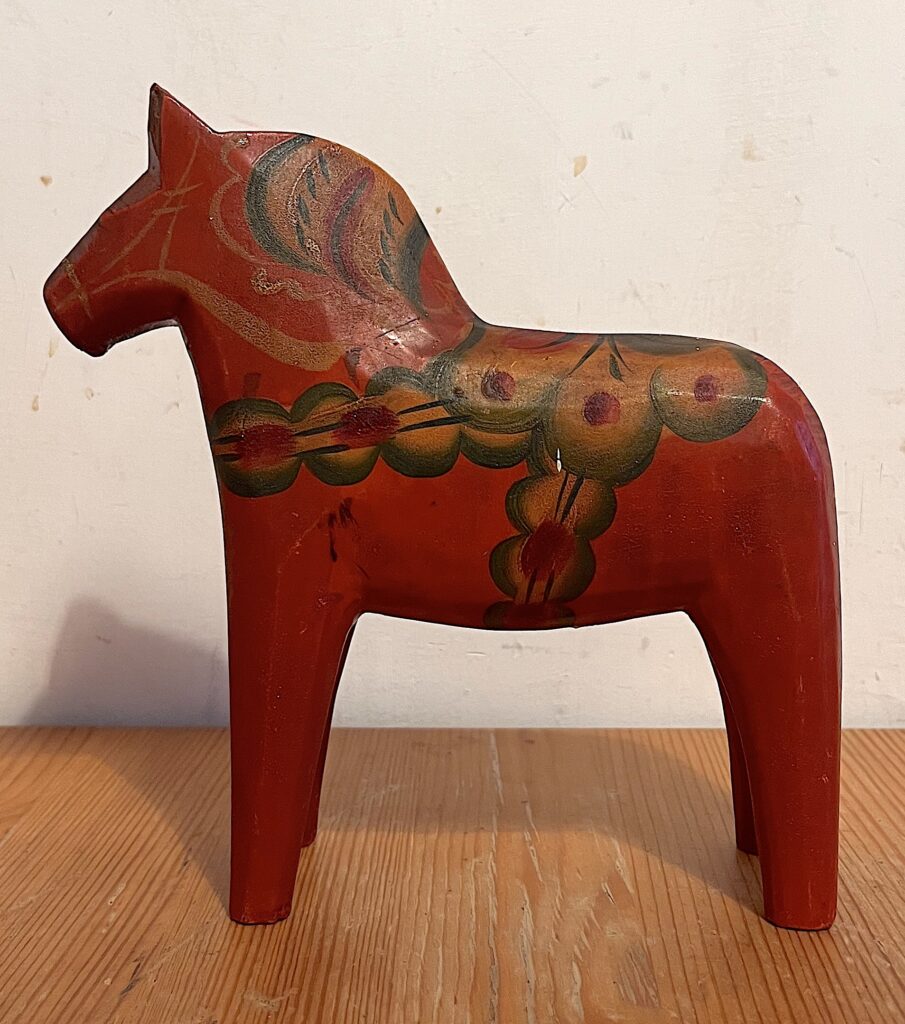 Cavallo Dala svedese vintage in legno rosso aranciato, con decorazioni floreali dipinte a mano nei toni del verde e dell'ocra, attribuito a Nils Olsson.